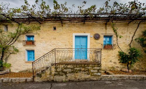 an old house with a blue door and stairs at Antica Dimora La Corona in San Pantaleo