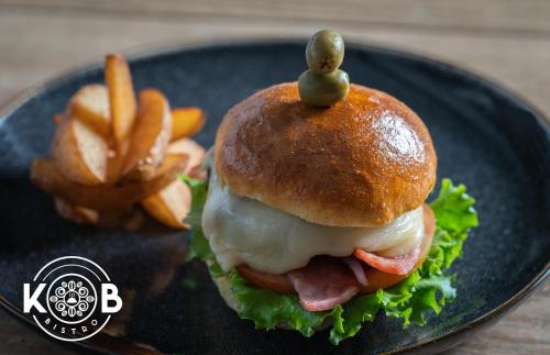 a sandwich with a pickle on top on a plate with fries at Hotel Puntarenas Beach in Puntarenas