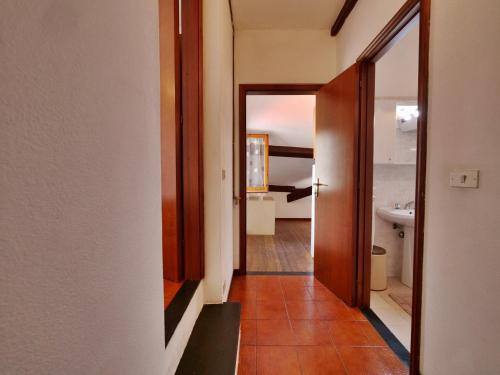 un couloir avec une porte menant à une salle de bains. dans l'établissement Tinetto Brezza di mare, à Deiva Marina
