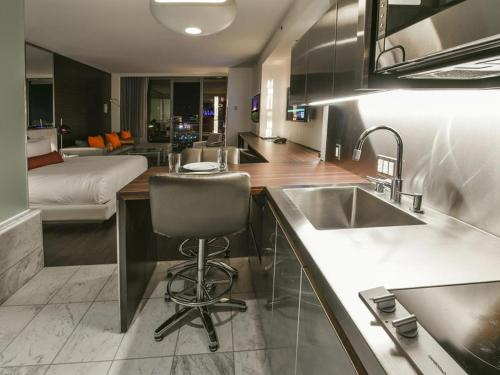 a kitchen with a sink and a chair in a room at Palms Place Studio with Balcony & Strip View in Las Vegas