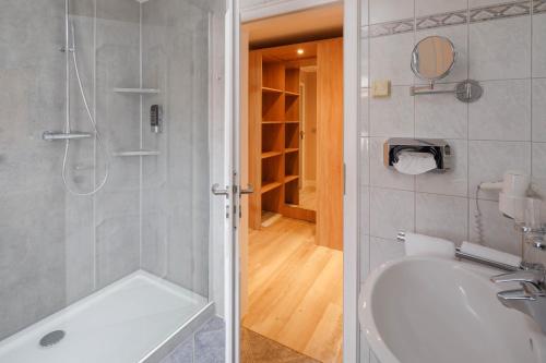 ein Badezimmer mit einer Dusche und einer weißen Badewanne in der Unterkunft Wattenkieker in Cuxhaven