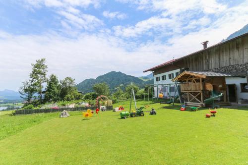 a playground with toys on the grass next to a building at Hagerhof in Walchsee