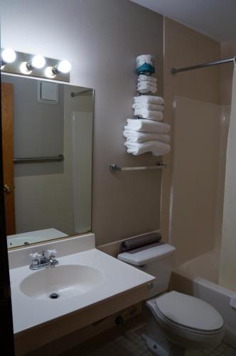 a bathroom with a sink and a toilet and a mirror at Fort Randall Casino & Hotel in Pickstown