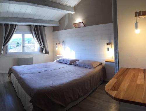 LOGIS HOTEL RESTAURANT L' Auberge d'Uzes في ازيس: غرفة نوم بسرير كبير ونافذة
