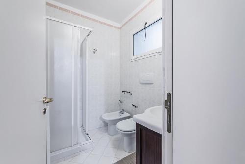 a white bathroom with a toilet and a sink at Manzoni House in Bari