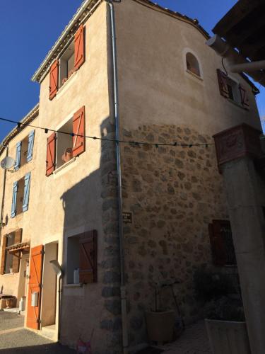 a building with red windows on the side of it at La Galisesagnoise in Briançonnet