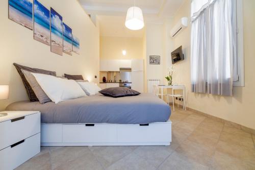 a bedroom with a large bed and a kitchen at Narciso Centralissimo in Sanremo