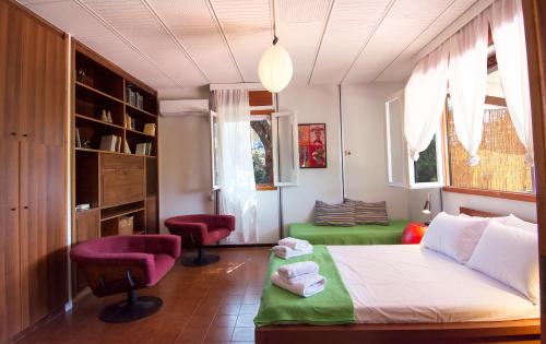 a bedroom with a bed and a chair in it at THE BOUCAMVIGLIA BEACH HOUSE in Saronida