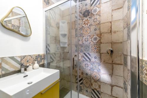 bagno con doccia, lavandino e specchio di Suite&Maré a Favignana