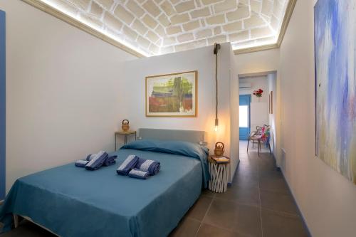 a bedroom with a blue bed with two pillows on it at Suite&Maré in Favignana