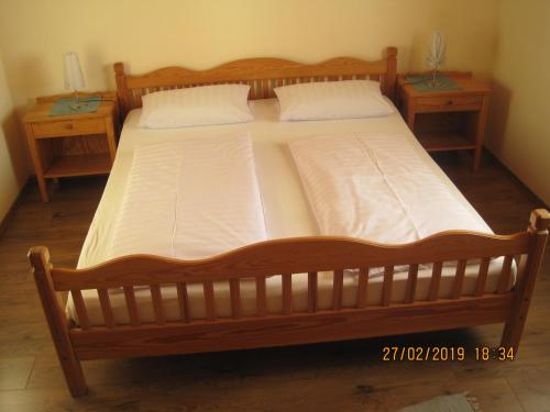 a large wooden bed in a room with two tables at Ferienwohnung Stilla Traurig in Arrach