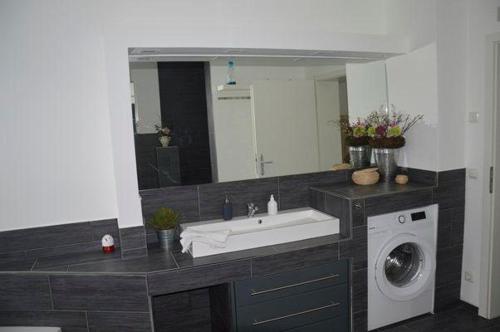 a bathroom with a sink and a washing machine at Home-Nr-5 in Roßwein