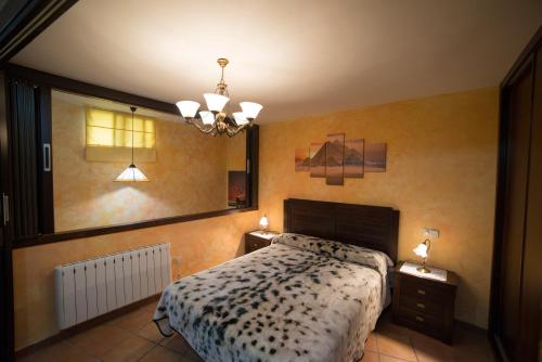 a bedroom with a bed and a lamp on the wall at Hostal Rural Los Telares in Pastrana