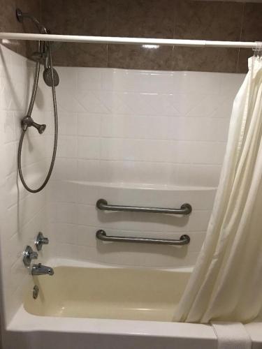 a bathroom with a shower and a bath tub at Sunrise Inn - Bradenton in Bradenton