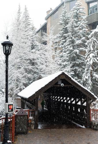 a snow covered building with a light pole and trees at Vail's Mountain Haus at the Covered Bridge in Vail