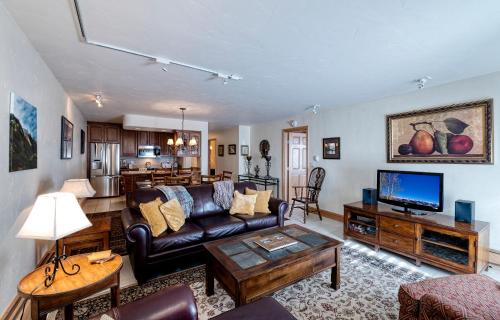 a living room with a couch and a tv at Vail's Mountain Haus at the Covered Bridge in Vail