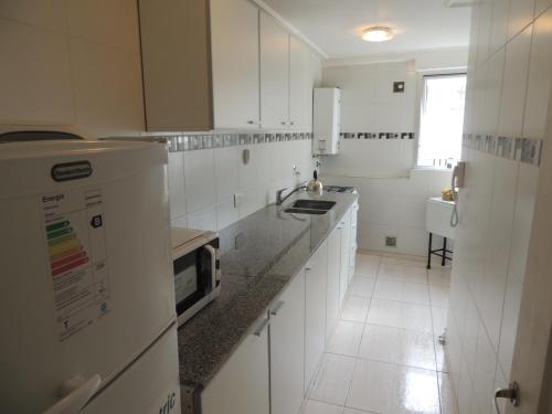 a white kitchen with white cabinets and a sink at Buenos Aires 435 in San Miguel de Tucumán