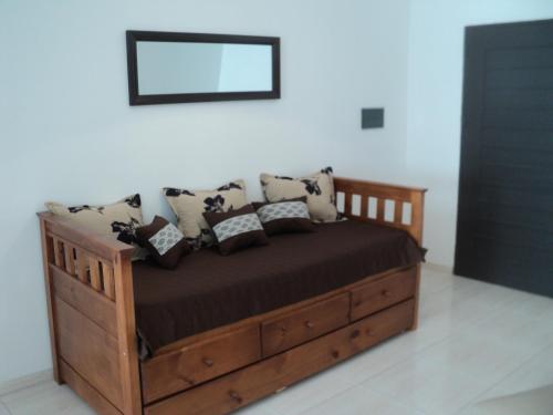 een houten bed met kussens in een kamer bij Buenos Aires 435 in San Miguel de Tucumán