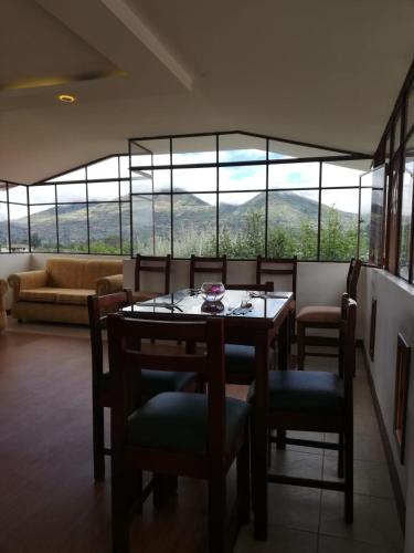 a dining room with a table and chairs and a couch at Quinta Spa El Rosal in Ambato
