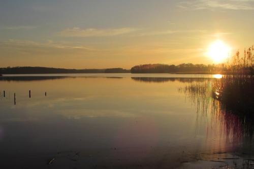 a view of a lake with the sun setting at Radlerzimmer (Zweibettzimmer) in Strasen