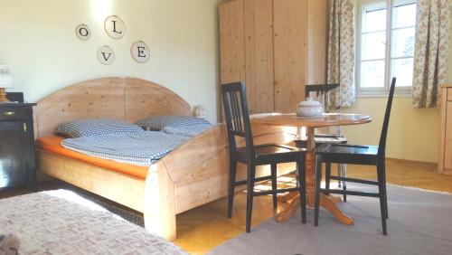 1 dormitorio con 1 cama y 1 mesa con sillas en Marta's House, en Bled