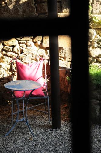 a pink chair and a table and a table and a chair at Chambre et Gite Le Roc sur l'Orbieu in Saint-Pierre-des-Champs