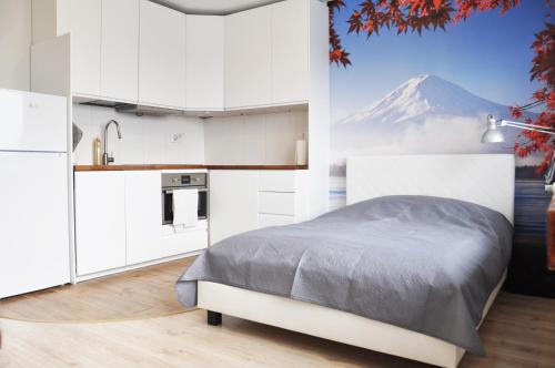 a bedroom with a bed and a mountain in the background at Os. 2 pułku 26 - studio by Homeprime in Kraków