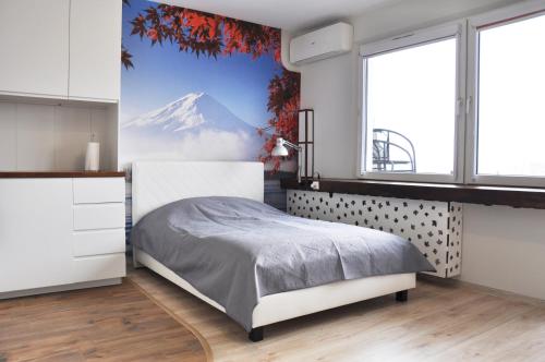 a bedroom with a bed with a view of a mountain at Os. 2 pułku 26 - studio by Homeprime in Kraków