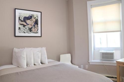una camera da letto con un letto bianco con un quadro sul muro di Stylish Downtown Studio in the South End, C. Ave #1 a Boston
