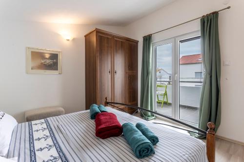 a bedroom with a bed with blue and red pillows on it at Apartment More in Kaštela