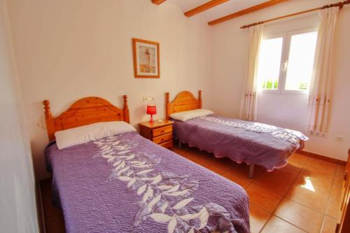 a bedroom with two beds and a window at Estrelizia - pretty holiday property with garden and private pool in Calpe in Calpe