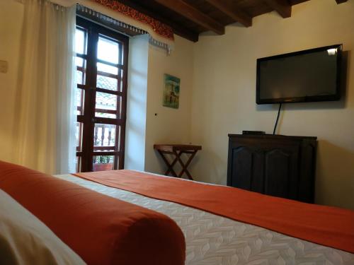 a bedroom with a bed and a flat screen tv at Casa India Catalina in Cartagena de Indias