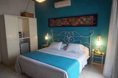 a bedroom with a bed with a blue wall at Casa India Catalina in Cartagena de Indias