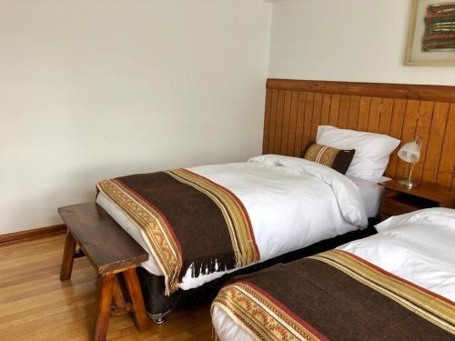 a hotel room with two beds and a table at Hostería Pionero in Cerro Castillo