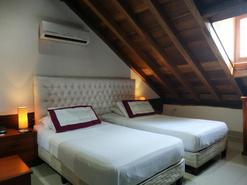 two beds sitting next to each other in a room at Casa India Catalina in Cartagena de Indias