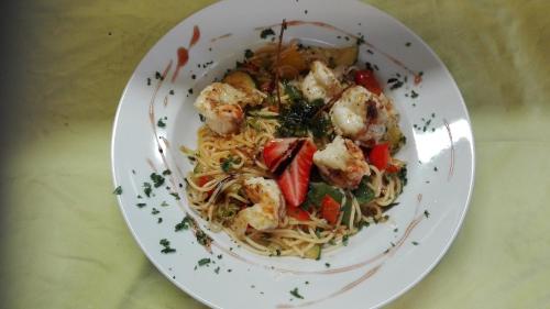 a plate of food with shrimp and pasta on a table at Pension Restaurant Meran in Abtenau