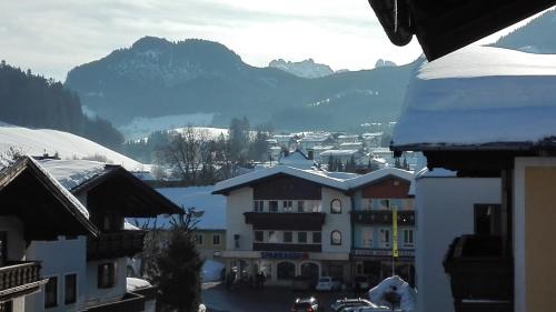 a view of a town with snow covered mountains at Pension Restaurant Meran in Abtenau