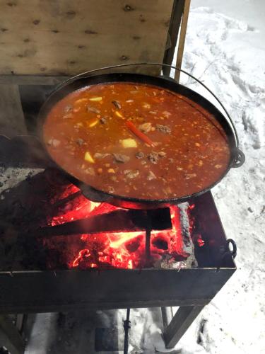 a large pot of soup on top of a fire at Gostynna sadyba Kit Bayun in Teterivka