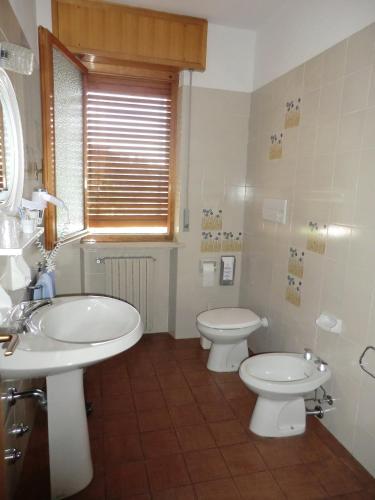 a bathroom with two sinks and two toilets at B&B Casa Sartori in Malcesine