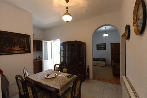 a dining room with a table and chairs and a room with a hallway at Apartments Astel in Bar