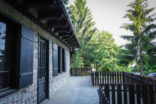 a building with a fence next to a sidewalk at Déjá Vu Szállás & Rendezvény Zirc in Zirc