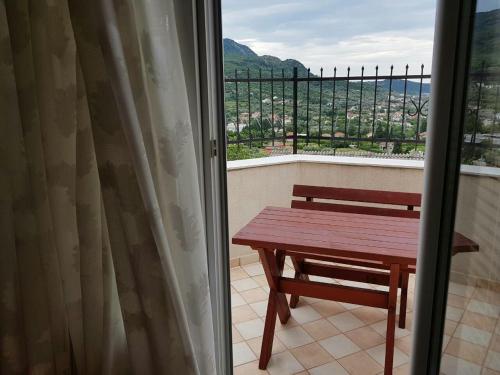 a table and bench on a balcony with a view at Apartments Astel in Bar