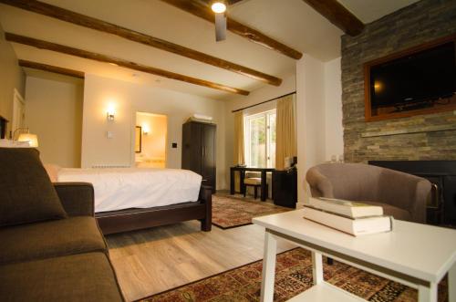 Galiano Oceanfront Inn & Spa في Galiano: غرفة نوم بسرير واريكة وطاولة