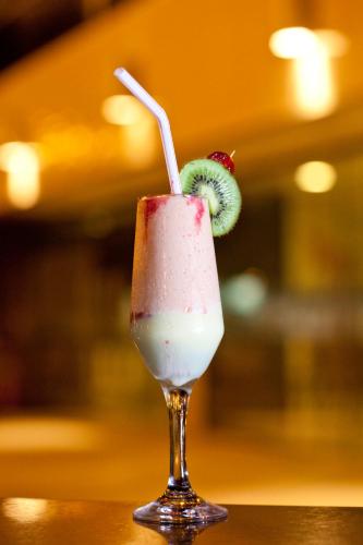 a drink with a strawberry and a kiwi on a table at Aquarios Praia Hotel in Aracaju