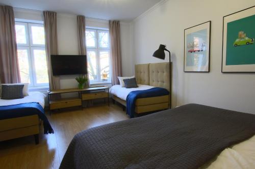 um quarto de hotel com duas camas e uma televisão em Apartament Grodzka 4 em Bydgoszcz