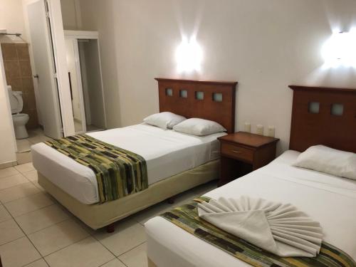 sypialnia z 2 łóżkami oraz łazienka z toaletą w obiekcie Hotel Xcalak w mieście Chetumal