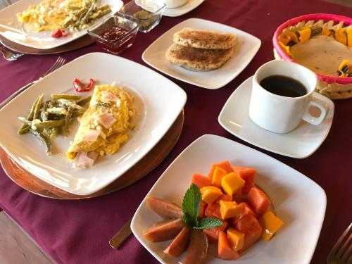 een tafel met borden eten en een kopje koffie bij CORTIJO LA CASONA & Bungalow al Pie de la Montaña in San Cristóbal de Las Casas