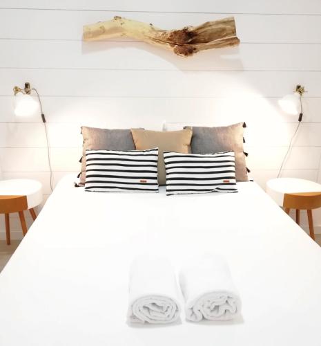 a bedroom with a white bed with two tables at Earth Element Apartment in Peniche