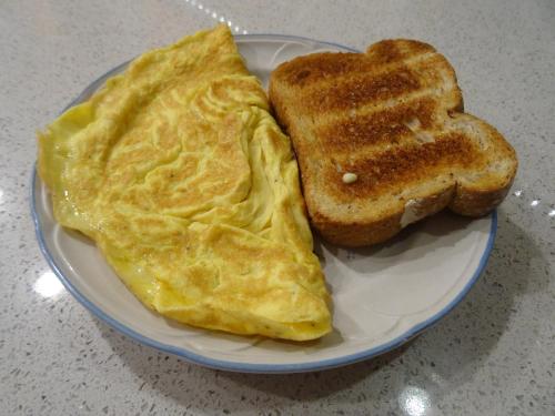 a plate with an omelet and two pieces of toast at Om sweet Home ॐ in Pokhara