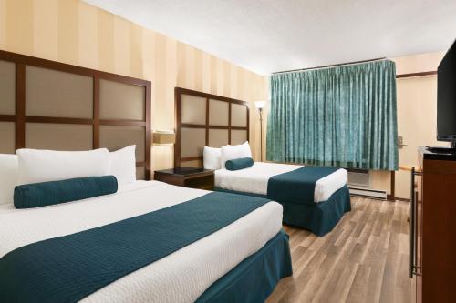 布蘭維爾的住宿－Hotel Days Inn Blainville & Centre de Conférence，酒店客房设有两张床和电视。